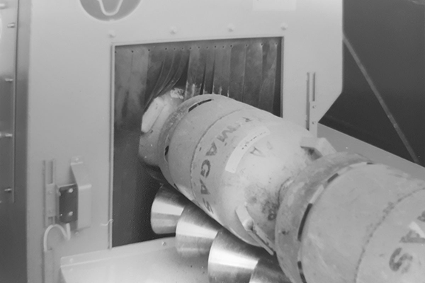 Gasflasche auf Rollenbahn in der Gasflaschenstrahlanlage – Reinigung und Oberflächenvorbereitung vor Beschichtung